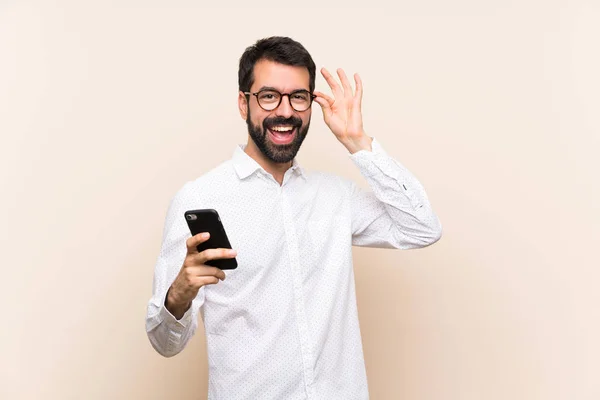 Junger Mann Mit Bart Hält Handy Mit Brille Und Glücklich — Stockfoto