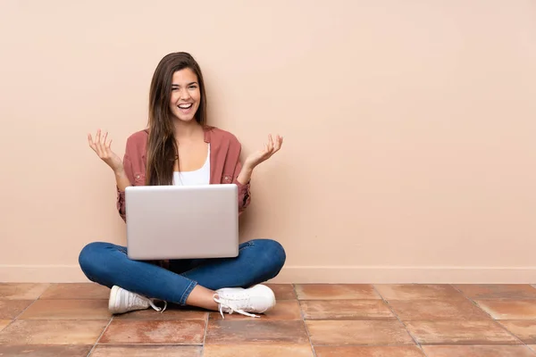 Genç Kız Dizüstü Bilgisayarla Yerde Oturuyor Gülümsüyor — Stok fotoğraf