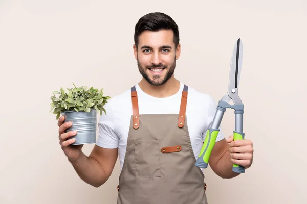 Gardener man holding a pruning shears over isolated background — Stock Photo, Image