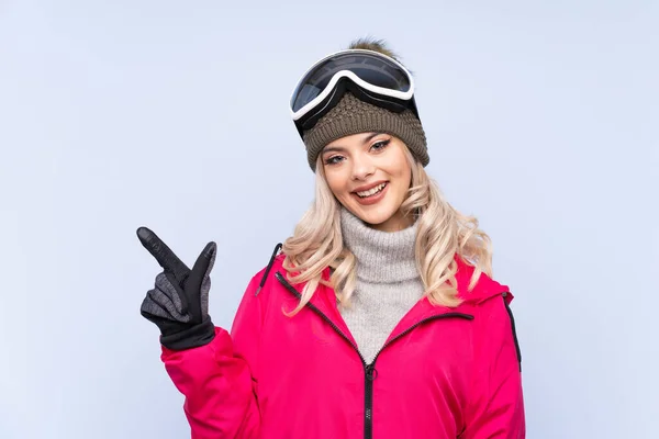 Lyžař Teenager Dívka Snowboarding Brýle Přes Izolované Modré Pozadí Ukazující — Stock fotografie