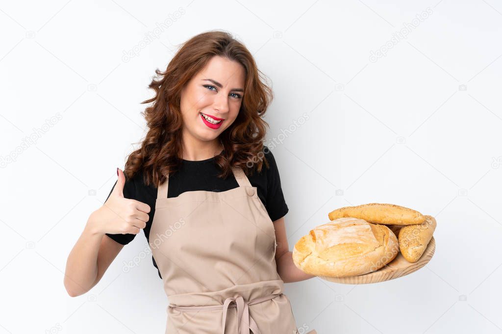 Woman in chef uniform. Female baker holding a table with several breads with thumbs up because something good has happened