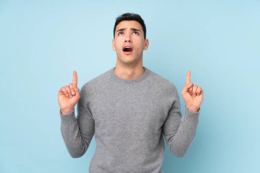 Mavi arka planda izole edilmiş genç beyaz adam işaret parmağıyla işaret etmek harika bir fikir.