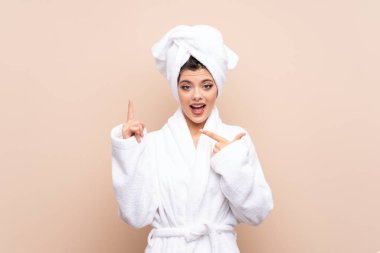 Bornozlu genç bir kız izole bir arka planı var ve yüzünde sürpriz bir ifade var.