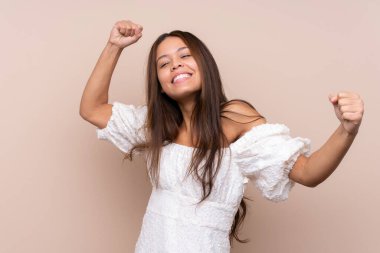 Genç Brezilyalı kız izole bir arka planda zaferi kutluyor.