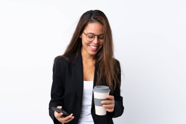 Cep telefonu ve kahvesi olan Brezilyalı genç bir kız izole edilmiş arka plandan kahve alıp götürüyor.