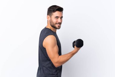 Sakallı, yakışıklı, soyutlanmış beyaz arka planı olan genç bir adam halter yapıyor.