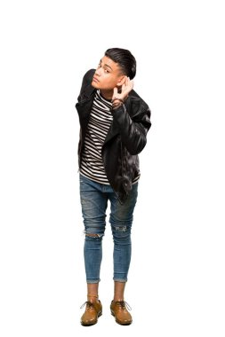 Bir şey dinleyen genç bir adamın, elini kulağın üzerine koyup izole edilmiş beyaz arka plan üzerine yaptığı uzun bir çekim.