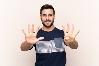 Sakallı, genç ve yakışıklı bir adam tecrit edilmiş arka planda dokuz parmağı var.