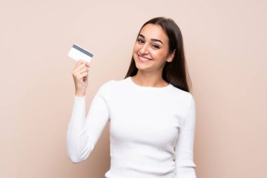 Soyutlanmış bir geçmişi olan genç bir kadın kredi kartı tutuyor.