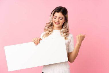 Soyutlanmış pembe arka planı olan genç bir kız, bir konsept eklemek için boş beyaz bir levha tutuyor.