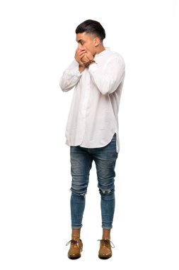 Genç bir adamın ağzını kapadığı ve izole edilmiş beyaz arka plan üzerinden yan tarafa baktığı uzun bir çekim.