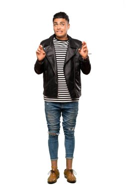 Parmakları çapraz olan ve izole edilmiş beyaz arka planda en iyisini dileyen genç bir adamın tam boy çekimi.