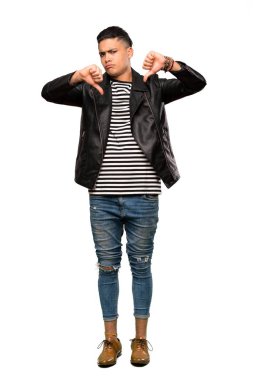 Genç bir adamın izole edilmiş beyaz arka planda baş parmağını gösterirken çekilmiş uzun bir fotoğraf.