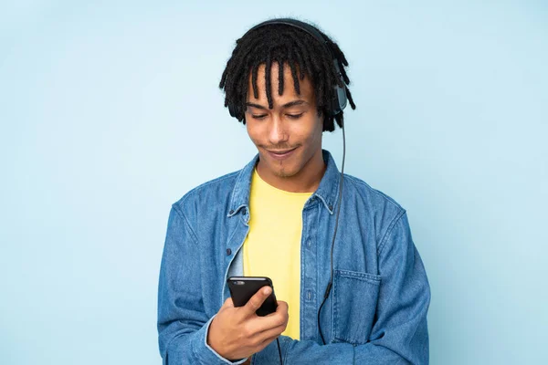 Jonge Afrikaanse Amerikaanse Man Geïsoleerd Blauwe Achtergrond Luisteren Muziek Zoek — Stockfoto