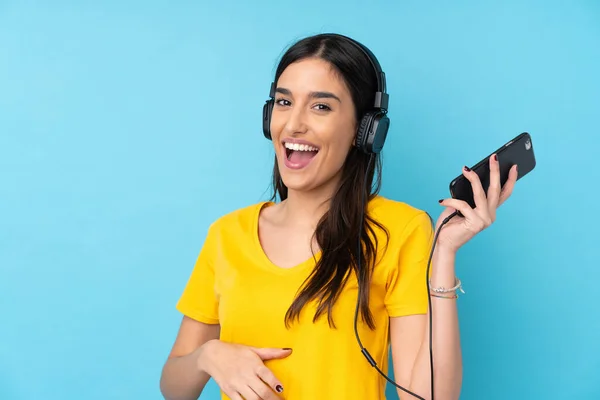 Young Brunette Woman Isolated Blue Background Listening Music Doing Guitar — 스톡 사진