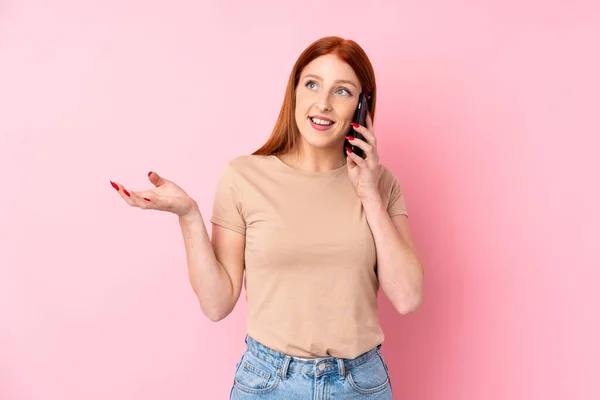 Jovem Ruiva Sobre Fundo Rosa Isolado Mantendo Uma Conversa Com — Fotografia de Stock