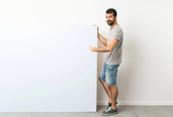 Young Handsome Man Beard Holding Big Blue Empty Placard Pointing — Stock Photo, Image