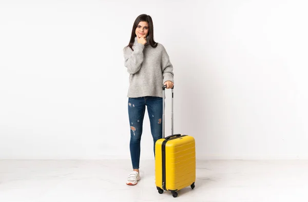 白い壁の上にスーツケースを持つ旅行者の女性の完全な長さの体笑って — ストック写真