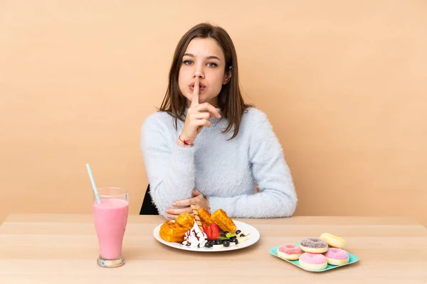 Chica Adolescente Comiendo Gofres Aislados Sobre Fondo Beige Mostrando Gesto —  Fotos de Stock