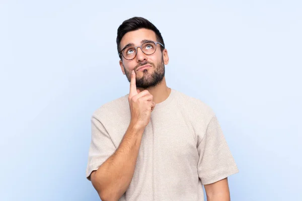 Joven Hombre Guapo Con Barba Sobre Fondo Azul Aislado Pensando — Foto de Stock