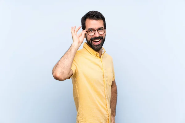 Jongeman Met Baard Geïsoleerde Blauwe Achtergrond Met Bril Glimlach — Stockfoto