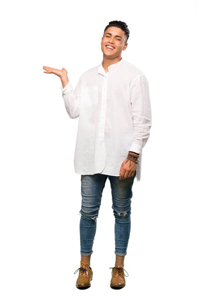 A full-length shot of a Young man holding copyspace imaginary on the palm to insert an ad over isolated white background