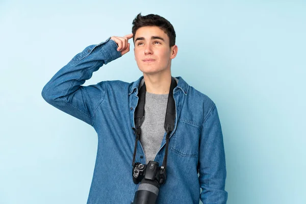 Teenager Photographer Man Isolated Blue Background Having Doubts Confuse Face — Stock Photo, Image