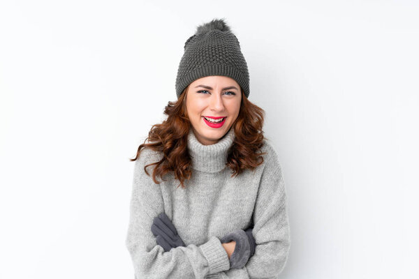 Young Russian woman with winter hat over isolated white background laughing