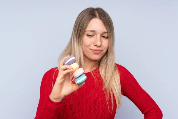 Fiatal Szőke Felett Elszigetelt Kék Háttér Gazdaság Színes Francia Macarons — Stock Fotó