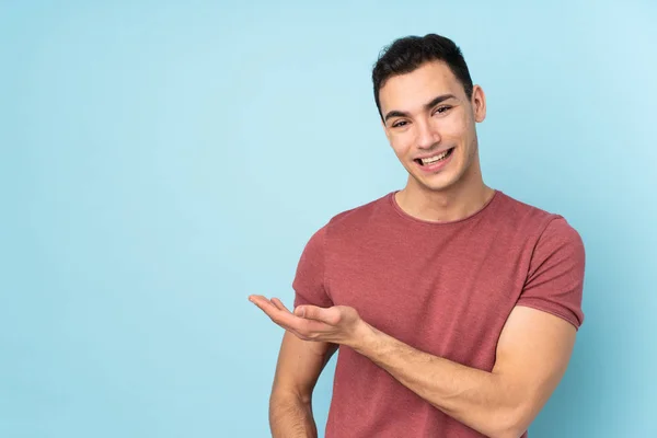 Jonge Blanke Knappe Man Geïsoleerd Blauwe Achtergrond Presenteren Van Een — Stockfoto