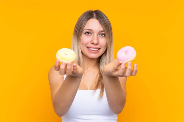 Jonge Blonde Vrouw Geïsoleerde Blauwe Achtergrond Met Een Donut Verdrietig — Stockfoto