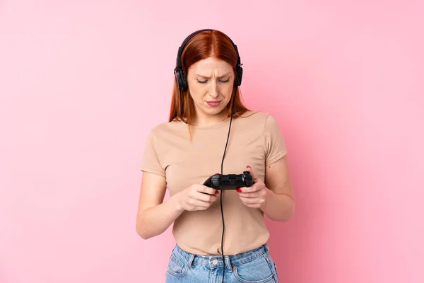 Jeune Rousse Femme Sur Fond Rose Isolé Jouer Des Jeux — Photo