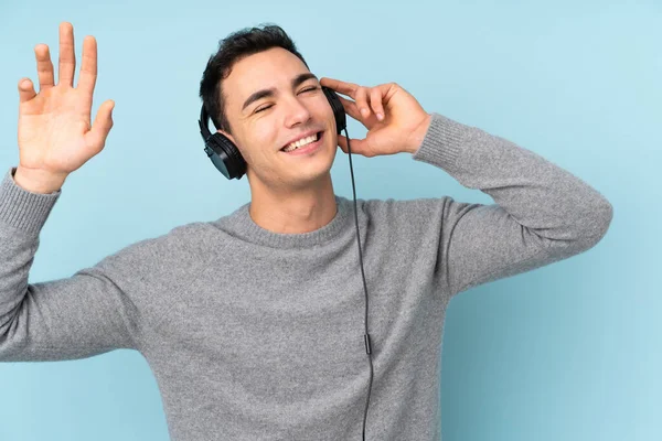 Jonge Kaukasische Knappe Man Geïsoleerd Blauwe Achtergrond Luisteren Muziek Dansen — Stockfoto