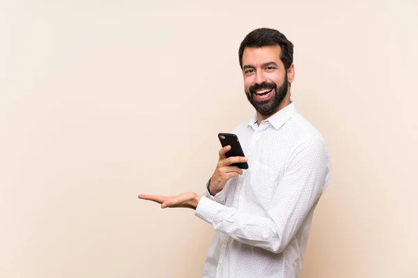 Junger Mann Mit Bart Hält Ein Handy Der Hand Und — Stockfoto