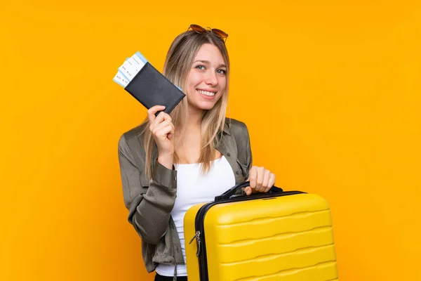 若いですブロンド女性以上隔離された黄色の背景で休暇とともにスーツケースとパスポート — ストック写真