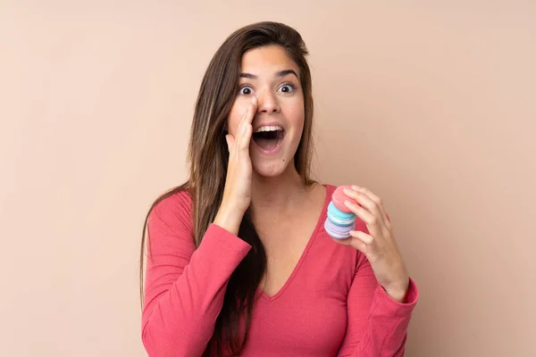 Ragazza Adolescente Sfondo Isolato Tenendo Macaron Francesi Colorati Gridando — Foto Stock