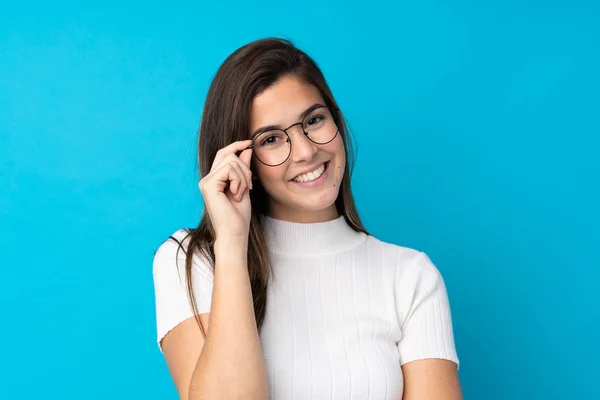 Teenager Mädchen Über Isolierten Blauen Hintergrund Mit Brille Und Glücklich — Stockfoto