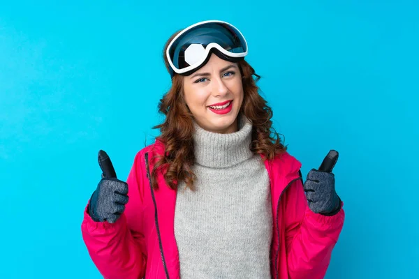 Skier Kobieta Okularach Snowboardowych Odizolowanej Niebieskiej Ścianie Dając Kciuki Górę — Zdjęcie stockowe