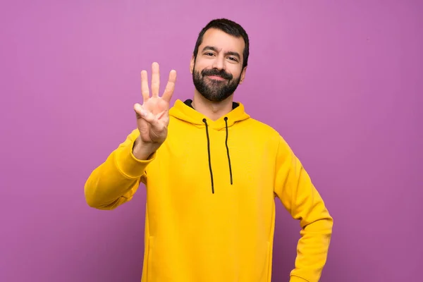 Bonito Homem Com Camisola Amarela Feliz Contando Três Com Dedos — Fotografia de Stock