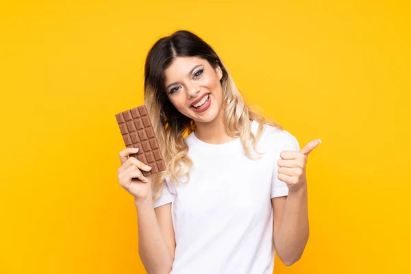 Teenager Dívka Izolované Žlutém Pozadí Čokoládovou Tabletu Palcem Nahoru — Stock fotografie