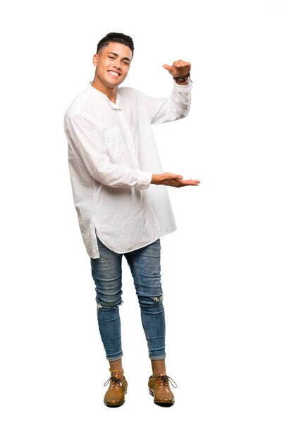 A full-length shot of a Young man holding copyspace to insert an ad over isolated white background