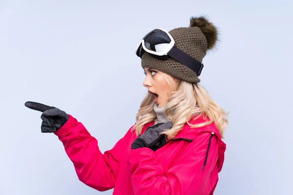 Skier Nastolatka Dziewczyna Okulary Snowboardowe Odizolowanym Niebieskim Tle Wskazując Palcem — Zdjęcie stockowe