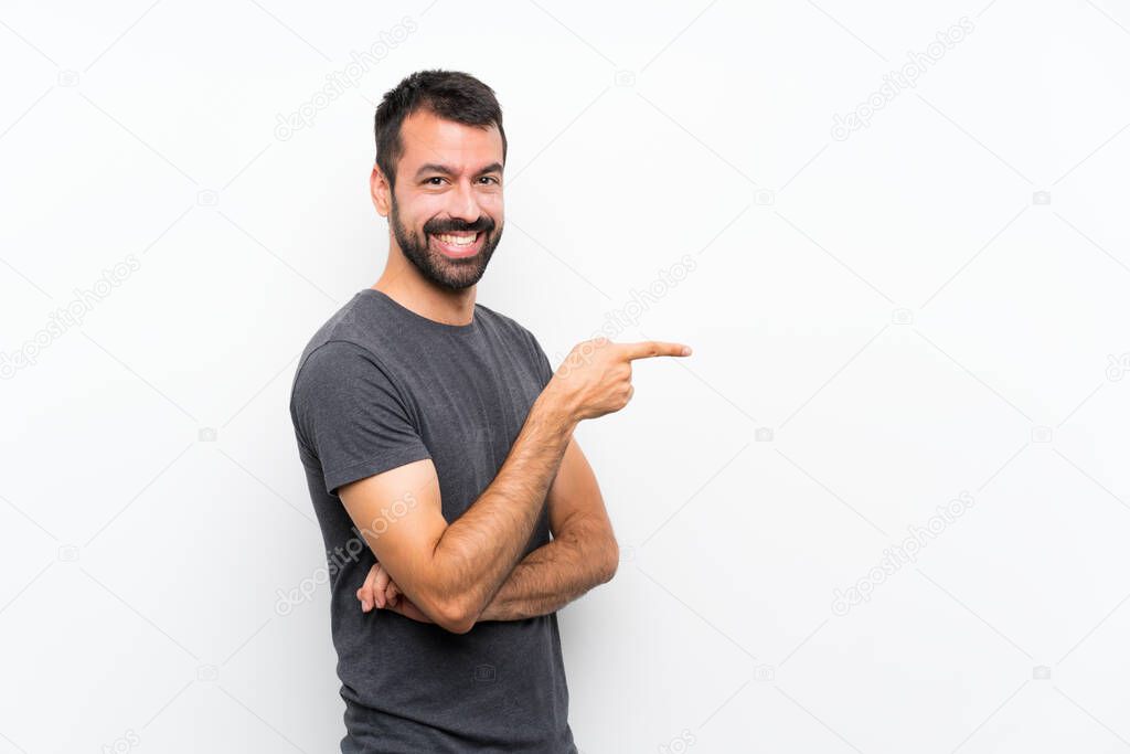 Young handsome man over isolated white background pointing finger to the side