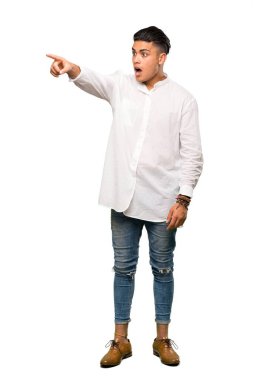 Genç bir adamın izole edilmiş beyaz arkaplanı işaret ettiği uzun bir çekim.