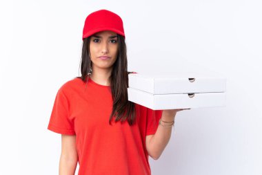 Pizza dağıtan kadın üzgün bir ifadeyle izole edilmiş beyaz duvarın üzerinde pizza tutuyor.