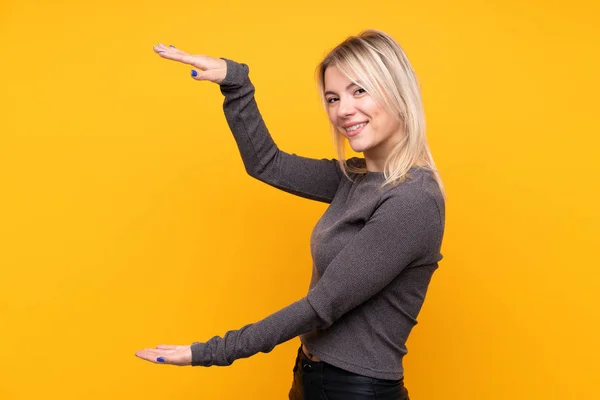 Mujer Rubia Joven Sobre Fondo Amarillo Aislado Sosteniendo Copyspace Para —  Fotos de Stock