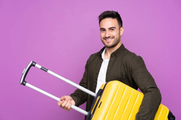 Jovem Homem Bonito Sobre Fundo Roxo Isolado Férias Com Mala — Fotografia de Stock