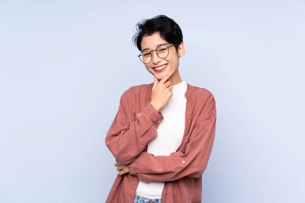 Joven Chica Asiática Sobre Fondo Azul Aislado Con Gafas Sonriendo — Foto de Stock