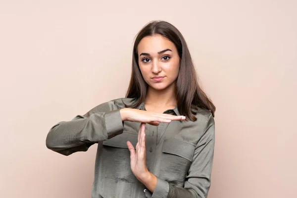 孤立した背景の上に若い女の子は タイムアウトジェスチャーを作ります — ストック写真