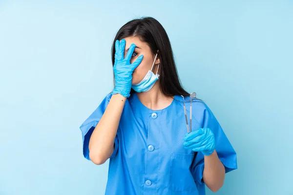 Mladá Žena Zubař Drží Nástroje Přes Izolované Modré Pozadí Zakrývající — Stock fotografie